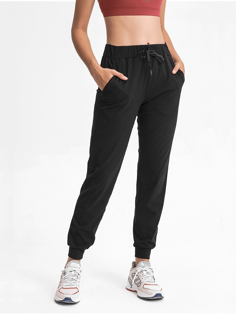 Woman wearing Sports Breathable Loose Women's Training Pants with adjustable high waist, black color, perfect for workouts.